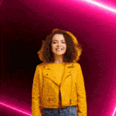 a woman in a yellow jacket stands in front of a pink light