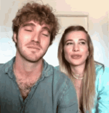 a man and a woman are sitting next to each other with their eyes closed and smiling .