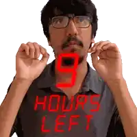 a man with glasses and a beard is holding up his hands in front of a sign that reads 9 hours left