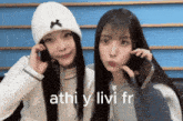 two girls are talking on their cell phones and the words athi y livi fr are on the bottom of the image
