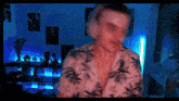 a man in a hawaiian shirt is standing in a room with blue lights