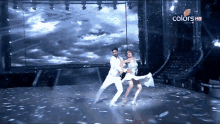 a man and a woman are dancing on a stage with the words colors hd on the bottom right