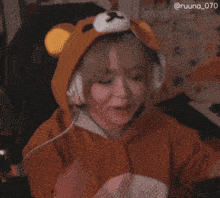 a woman wearing a bear hat and headphones applauds