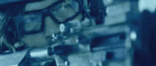 a man wearing glasses and a helmet is holding a gun in his hand .