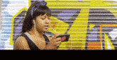 a woman wearing headphones is listening to music on a cell phone