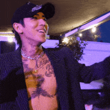 a man wearing a hat and a striped jacket has a tattoo on his chest that says ' brian ' on it