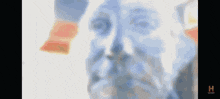 a blurry image of a man 's face with the letter h on the bottom