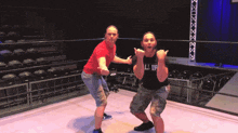 two men in a wrestling ring one of whom is wearing a black shirt that says all in