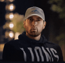 a man wearing a baseball cap and a black hoodie with the word lions on it