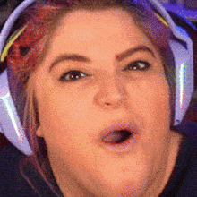 a woman wearing headphones is making a funny face with her mouth open .