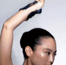a close up of a woman 's arm with a bun on her head