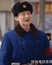 a man wearing a hat and a blue coat with chinese writing on the bottom