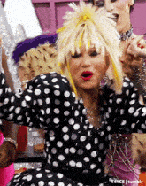 a woman wearing a black and white polka dot dress with a yellow ponytail