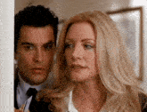 a man and a woman are standing next to each other and the woman is looking at the man .