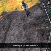 a person riding a bike on a dirt road with the words looking at us like we did it