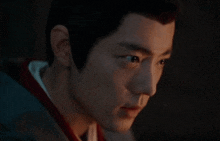 a close up of a man 's face with a dark background .