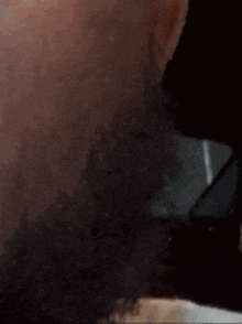a close up of a person 's face with a beard and glasses .