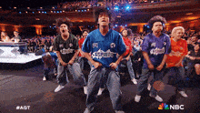 a group of people are dancing in front of a crowd and the nbc logo is on the bottom