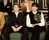 a group of men are sitting on a green couch in a room .
