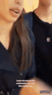 a man and a woman are standing next to each other and the woman is talking to the man .