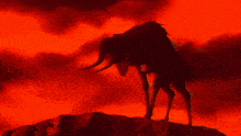 a silhouette of a monster with horns standing on a hill
