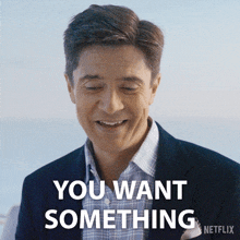 a man in a suit is smiling and says you want something