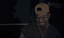 a man wearing a hat and a necklace is smiling