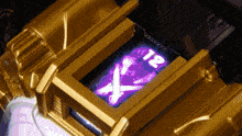 a gold object with a purple x and the number 12 on it