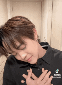 a tiktok video of a young man with his hands on his heart