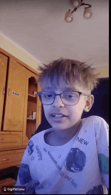 a boy wearing glasses and a shirt that says new on it