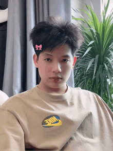 a boy wearing a nike shirt with a pink bow on his head