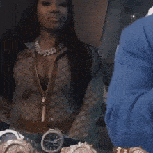 a woman is standing in front of a mirror with a bunch of watches on the table .