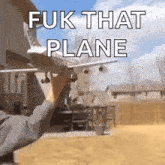 a person is standing in front of a house with a plane flying in the background .