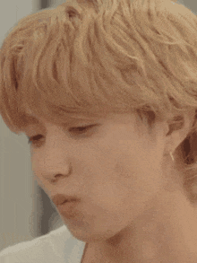 a close up of a young man 's face with blonde hair .