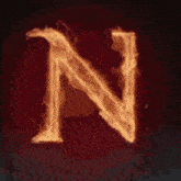 the letter n is surrounded by flames on a dark background .