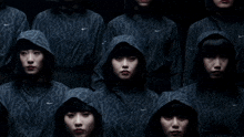 a woman wearing a hooded jacket is standing in the dark