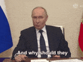 a man in a suit and tie is sitting at a desk and saying " and why should they "