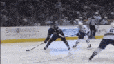 a hockey game is being played in front of an advertisement for san manuel