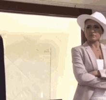 a woman wearing a white hat and a pink jacket
