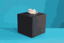 a black box with tissues in it on a blue table