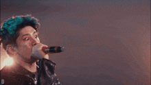 a man singing into a microphone with the letter d visible in the corner