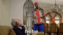 a man is talking on a cell phone while another man holds a bag of chips and says " he he "