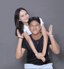 a woman is sitting on a man 's shoulders