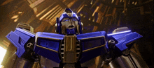 a close up of a blue and gold robot with the letter j on it