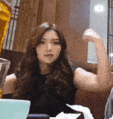 a woman is flexing her arm in a restaurant