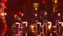 a group of women are sitting on stools on stage