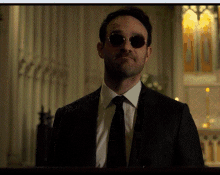 a man in a suit and tie with sunglasses on