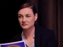 a woman is holding a piece of paper with a picture of a car on it .