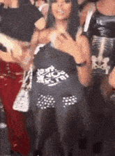 a woman is standing in a crowd of people holding a shirt that says `` i 'm not a fan '' .