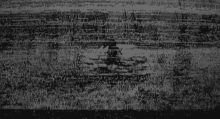 a black and white photo of a person riding a motorcycle on a road .